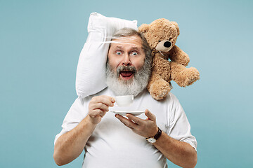 Image showing Tired man sleeping at home having too much work. Bored businessman with pillow and toy bear