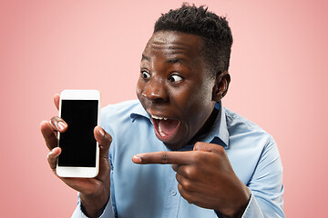 Image showing Indoor portrait of attractive young black man holding blank smartphone