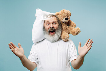 Image showing Tired man sleeping at home having too much work. Bored businessman with pillow and toy bear