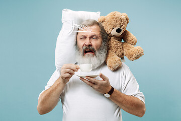 Image showing Tired man sleeping at home having too much work. Bored businessman with pillow and toy bear