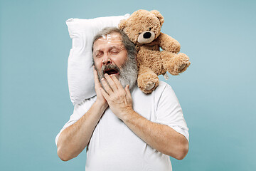 Image showing Tired man sleeping at home having too much work. Bored businessman with pillow and toy bear