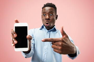 Image showing Indoor portrait of attractive young black man holding blank smartphone