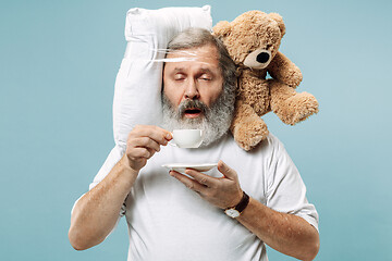 Image showing Tired man sleeping at home having too much work. Bored businessman with pillow and toy bear