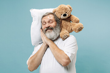 Image showing Tired man sleeping at home having too much work. Bored businessman with pillow and toy bear