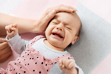 Image showing mother\'s hand touching crying little baby daughter