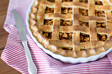 Image showing close up of apple pie in baking mold and knife