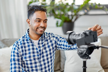 Image showing indian male video blogger adjusting camera at home