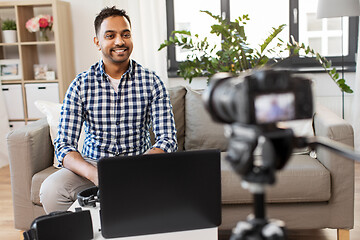 Image showing male blogger with camera videoblogging at home