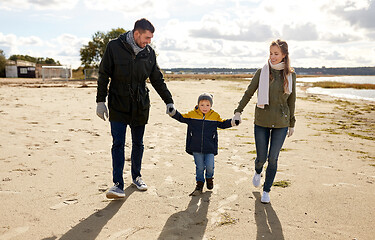 Image showing happy family walking along autumn beach