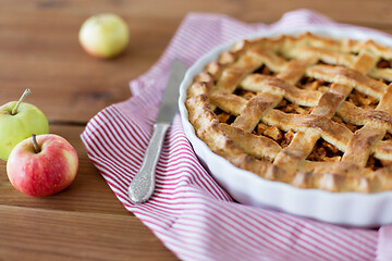 Image showing close up of apple pie in baking mold and knife