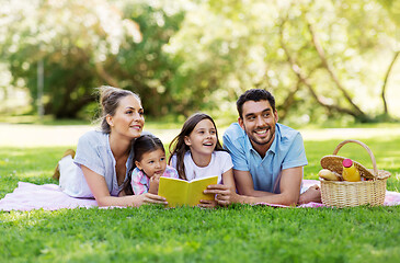 Image showing family reading book on picnic in summer park