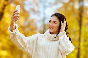 Image showing woman taking selfie by smartphone at autumn park