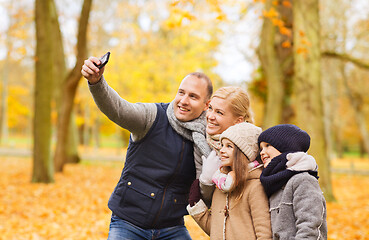 Image showing happy family with camera in autumn park