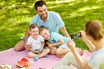 Image showing mother taking picture of family on picnic at park