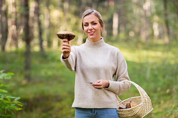 Image showing young woman with mushroom in autumn forest