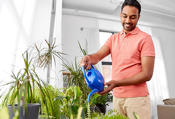 Image showing indian man watering houseplants at home