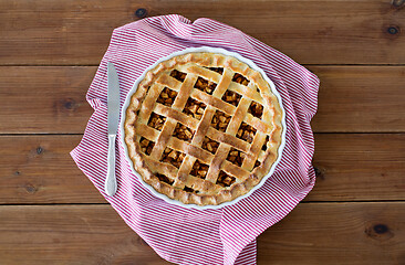 Image showing close up of apple pie in baking mold and knife