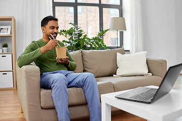 Image showing indian man with laptop eating takeout food at home