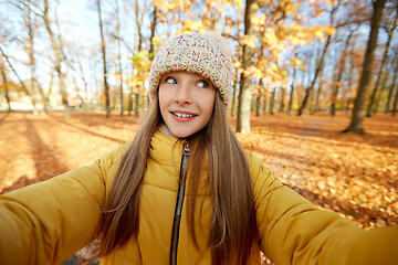 Image showing happy girl taking selfie at autumn park