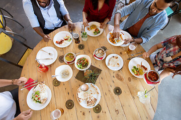 Image showing international friends eating at restaurant