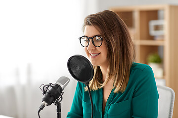 Image showing woman with microphone recording podcast at studio