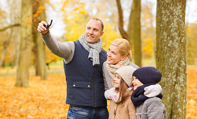 Image showing happy family with camera in autumn park