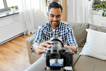 Image showing indian male video blogger adjusting camera at home