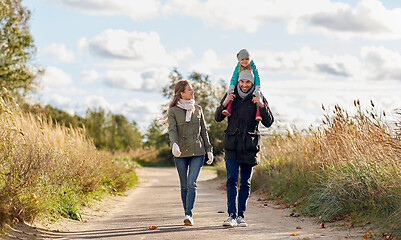 Image showing happy family walking along autumn road