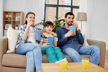 Image showing happy family with popcorn watching tv at home