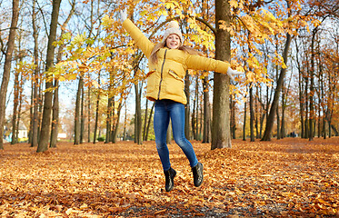 Image showing happy girl jumping at autumn park