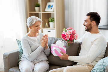 Image showing son giving present and flowers to senior mother