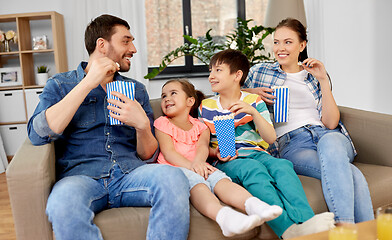 Image showing happy family with popcorn watching tv at home