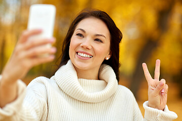 Image showing woman taking selfie by smartphone at autumn park