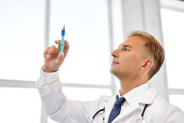 Image showing smiling doctor with syringe at hospital