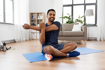 Image showing man training and stretching arm at home