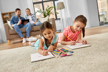 Image showing happy sisters drawing in sketchbooks at home