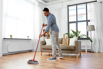 Image showing man with broom cleaning floor at home