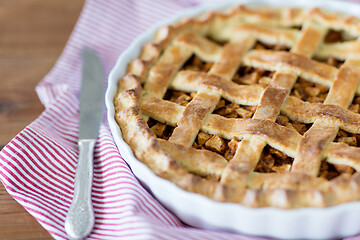 Image showing close up of apple pie in baking mold and knife