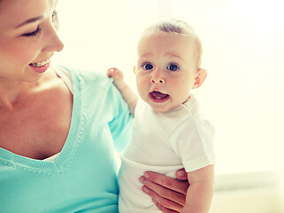 Image showing happy young mother with little baby at home