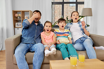 Image showing scared family with popcorn watching horror on tv