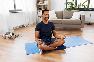 Image showing indian man meditating in lotus pose at home