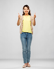 Image showing happy asian woman showing thumbs up over grey