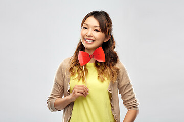 Image showing happy asian woman with big red bow tie