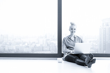 Image showing woman drinking coffee and using laptop at home