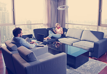 Image showing couple relaxing at  home using tablet and laptop computers