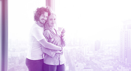 Image showing young couple enjoying morning coffee by the window