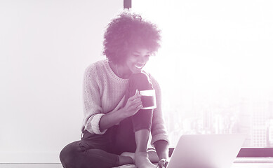 Image showing black woman in the living room on the floor