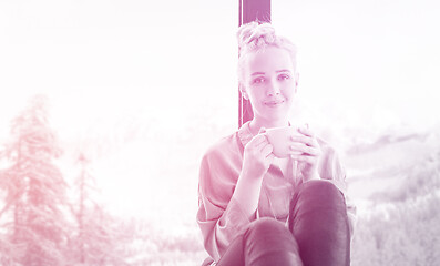 Image showing woman drinking coffee and using laptop at home