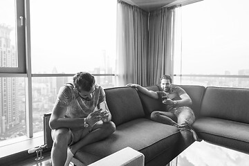 Image showing two young men using a mobile phones  at home