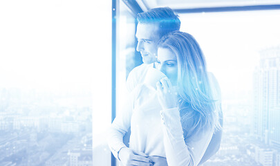 Image showing young couple enjoying morning coffee by the window